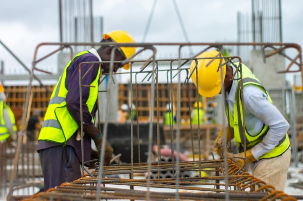 Men Working on a Construction Site while Wearing Hard Hats