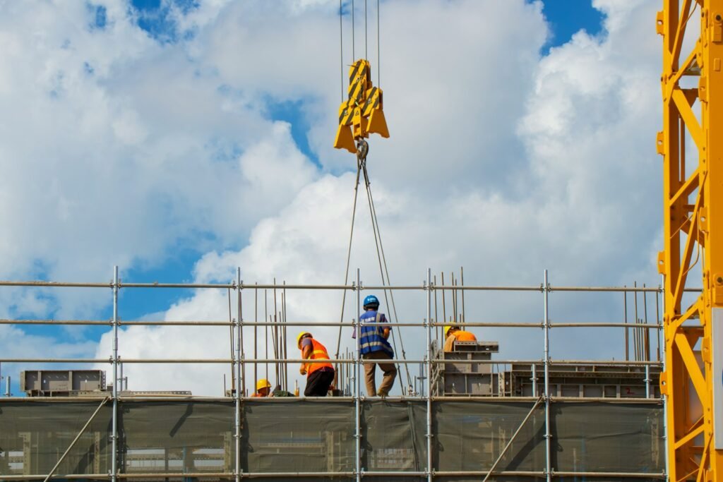 a group of men standing on top of a building under construction